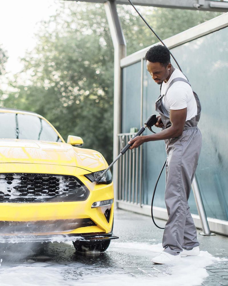 man-washing-his-luxury-yellow-car-under-high-press-TYJVQEK.jpg